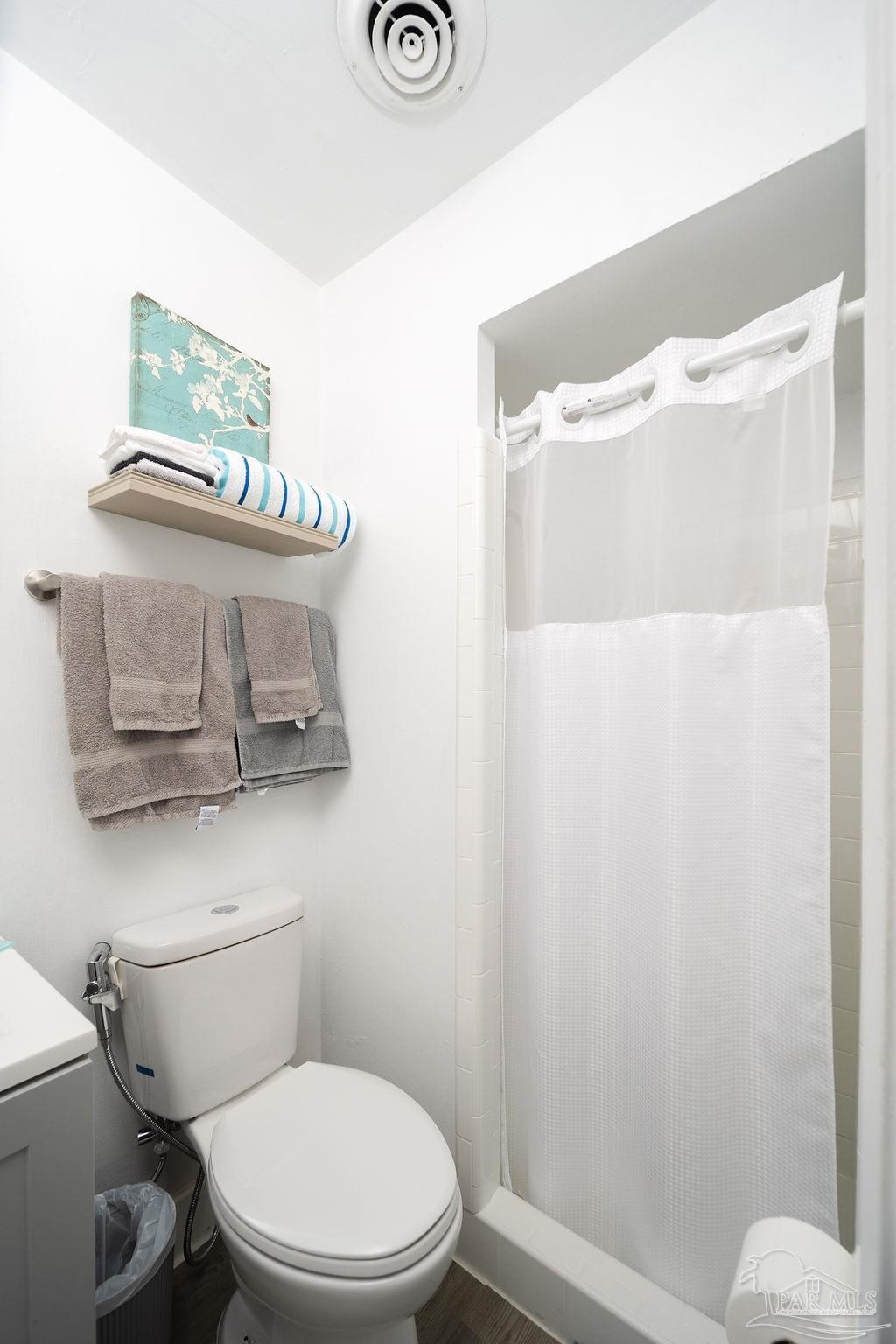 6841 Data Street Pensacola, FL 32504 - Photo 16 of 25 a white toilet sitting next to a bathroom sink