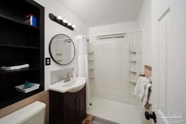 a bathroom with a sink toilet and a mirror