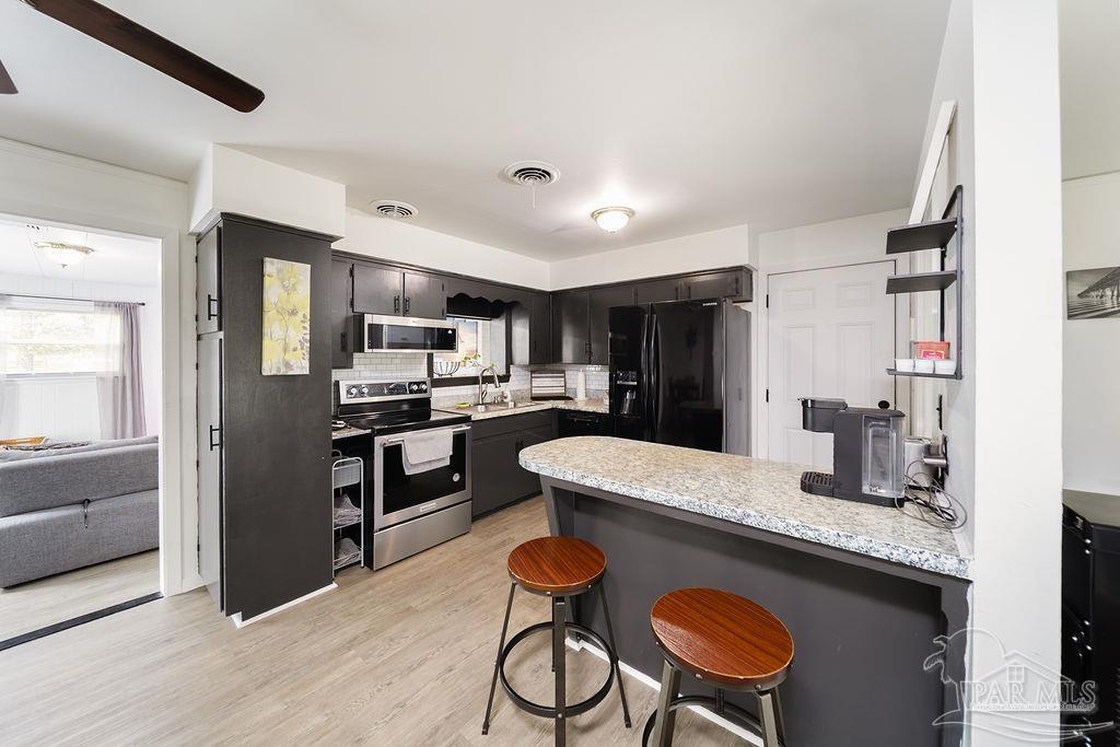 6841 Data Street Pensacola, FL 32504 - Photo 8 of 25 a kitchen with granite countertop stainless steel appliances a sink and a refrigerator