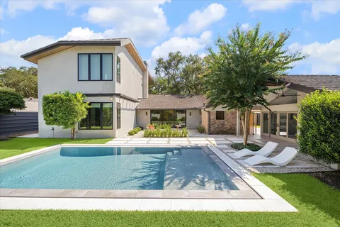 a view of a house with a swimming pool and a yard