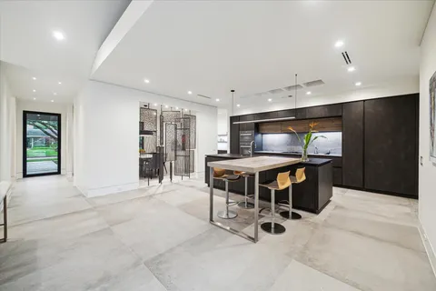 a kitchen with stainless steel appliances kitchen island granite countertop a refrigerator and a sink