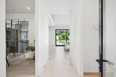 a view of a hallway with wooden floor and a bathroom