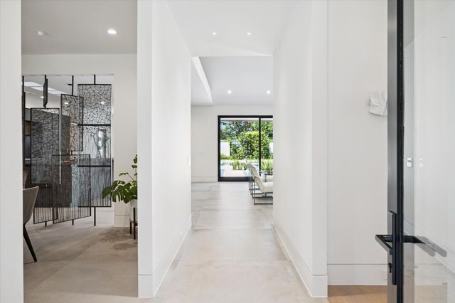 a view of a hallway with wooden floor and a bathroom