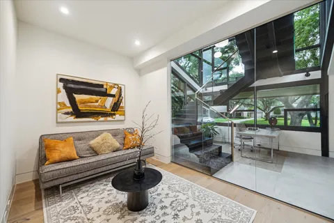 a living room with furniture a rug and a floor to ceiling window