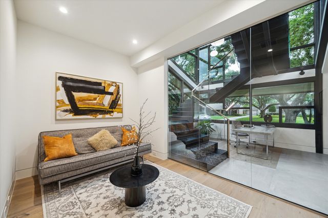 a living room with furniture a rug and a floor to ceiling window