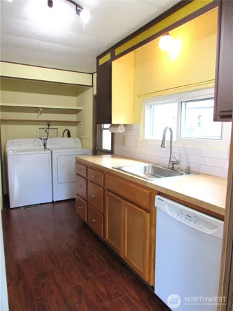a kitchen with a sink and wooden floor