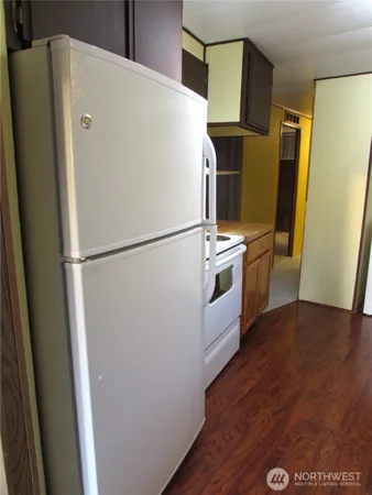 a white refrigerator freezer and a wooden floor