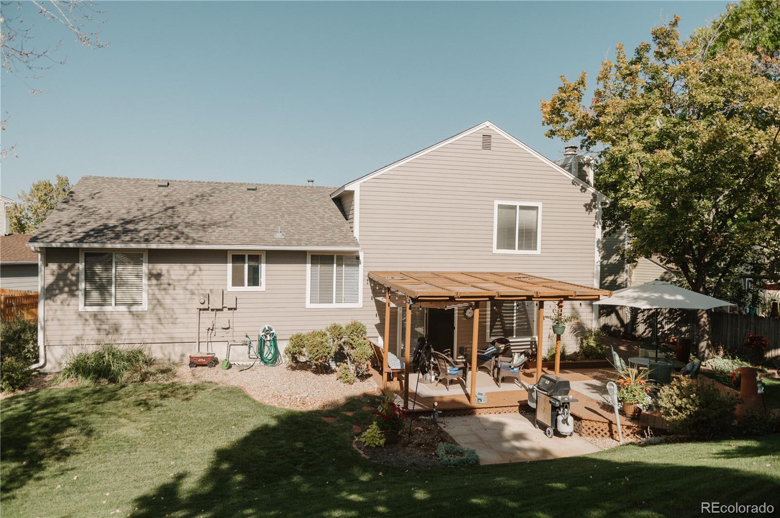 10340 West 100th Place Westminster, CO 80021 - Photo 24 of 25 a front view of house with yard outdoor seating and covered with trees