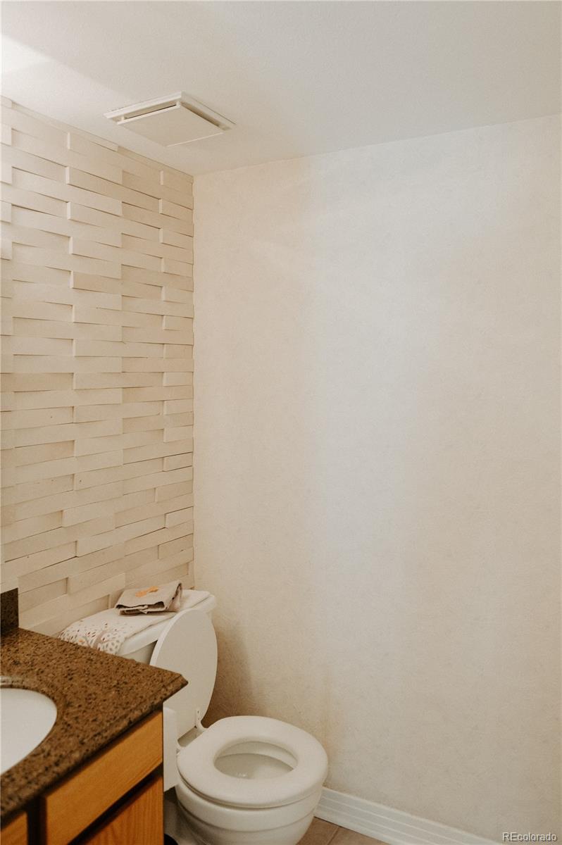 10340 West 100th Place Westminster, CO 80021 - Photo 7 of 25 a bathroom with a granite countertop toilet and a sink