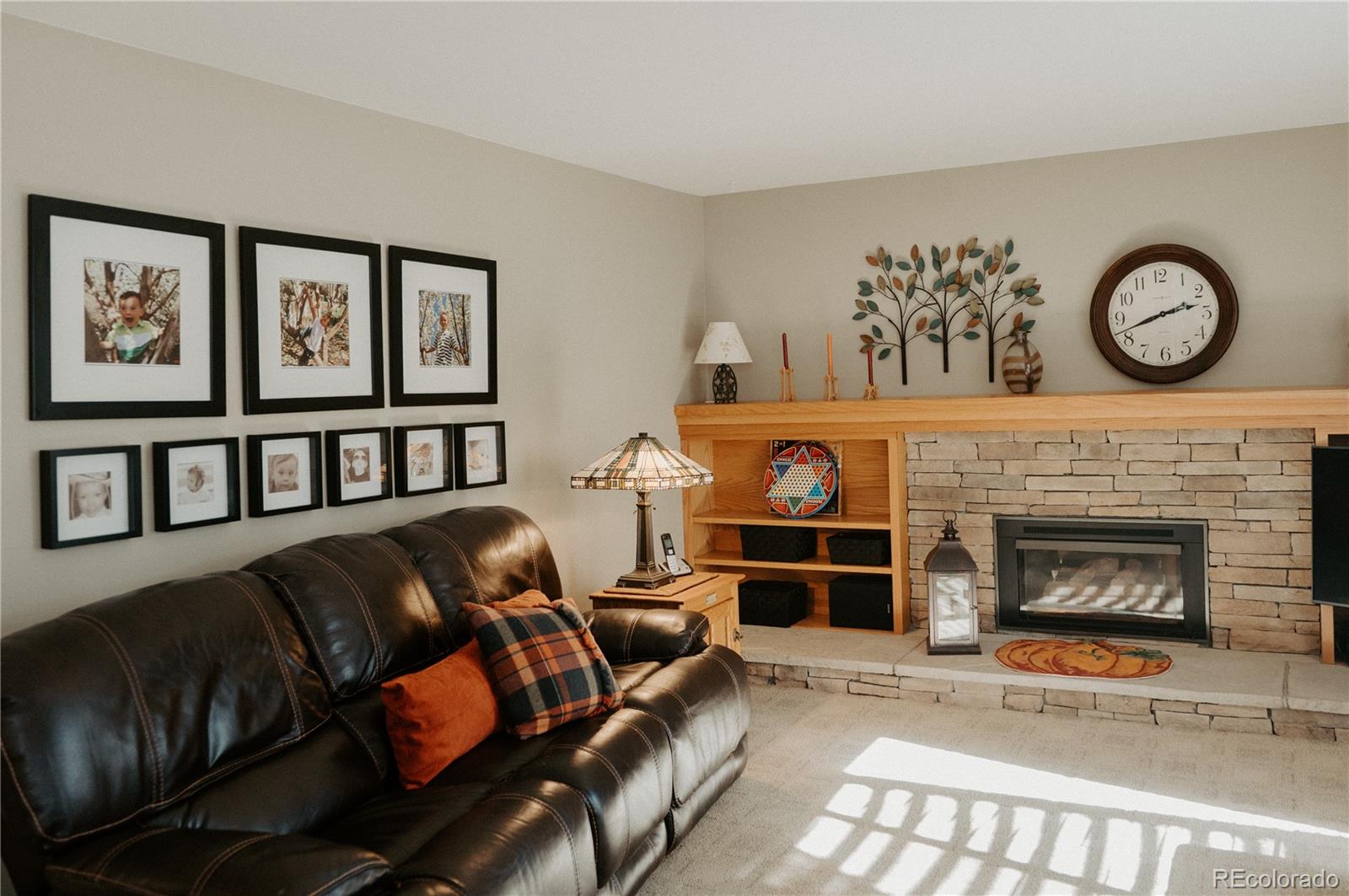 10340 West 100th Place Westminster, CO 80021 - Photo 8 of 25 a living room with furniture a fireplace and a large window