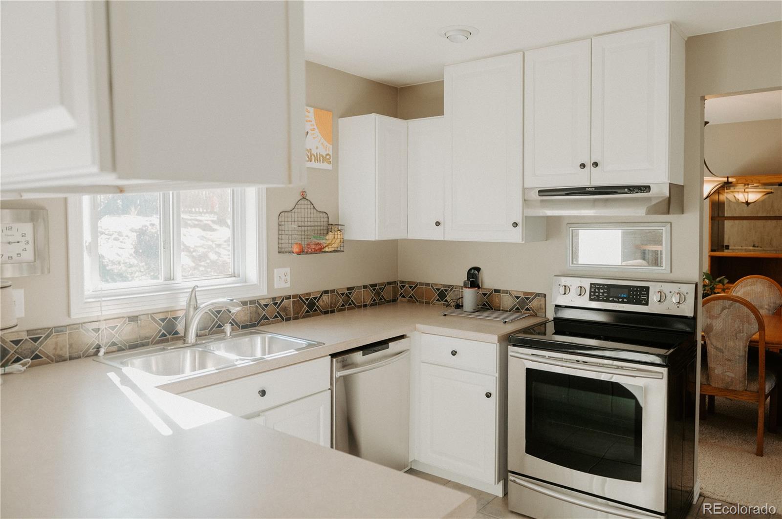 10340 West 100th Place Westminster, CO 80021 - Photo 9 of 25 a kitchen with granite countertop a sink stove and cabinets