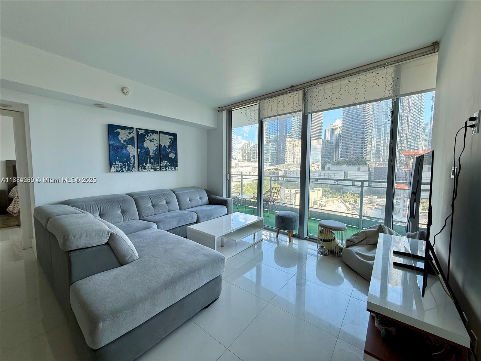 92 Southwest 3rd Street, Unit 1104 Miami, FL 33130 - Photo 3 of 17 a living room with furniture wooden floor and a large window