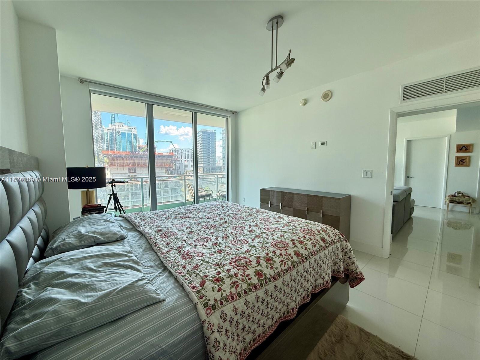 92 Southwest 3rd Street, Unit 1104 Miami, FL 33130 - Photo 6 of 17 a bedroom with a large bed and a balcony