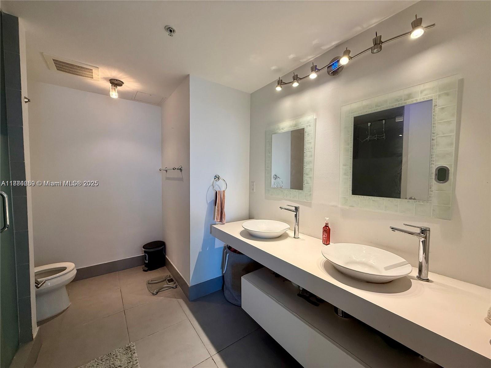 92 Southwest 3rd Street, Unit 1104 Miami, FL 33130 - Photo 7 of 17 a bathroom with a sink double vanity and a toilet