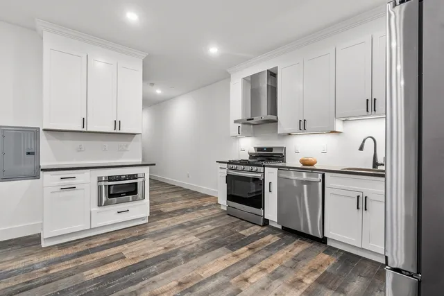 a kitchen with granite countertop a stove top oven and cabinets