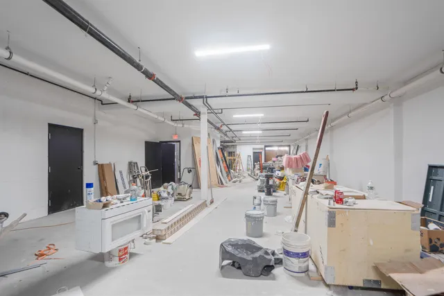 a room with gym equipment and view of kitchen