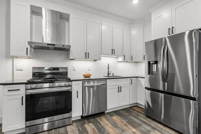 a kitchen with stainless steel appliances white cabinets and a stove