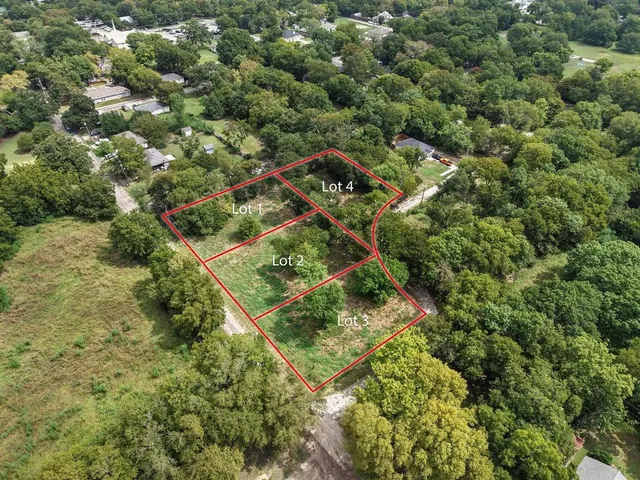an aerial view of residential houses with outdoor space and trees