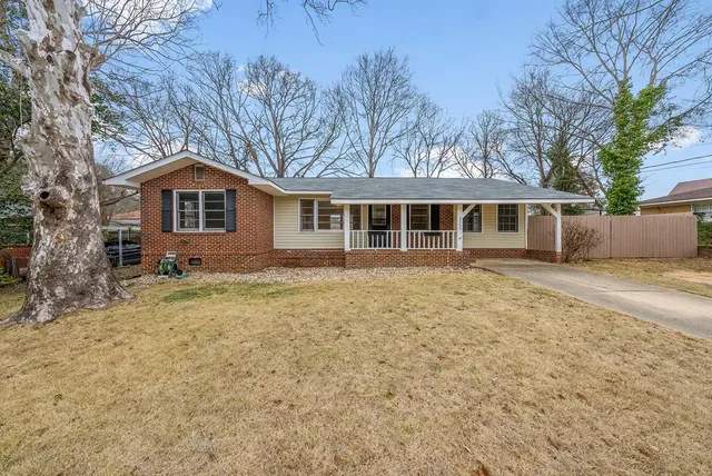 a front view of a house with a yard and trees