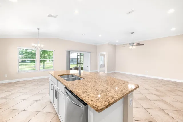 an empty room with kitchen island and natural light