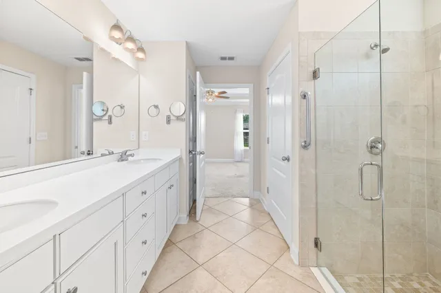 a spacious bathroom with a double vanity sink mirror and shower