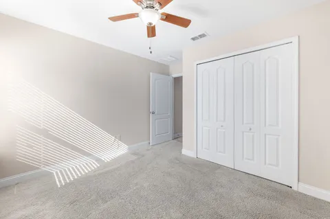 an empty room with a ceiling fan and a window