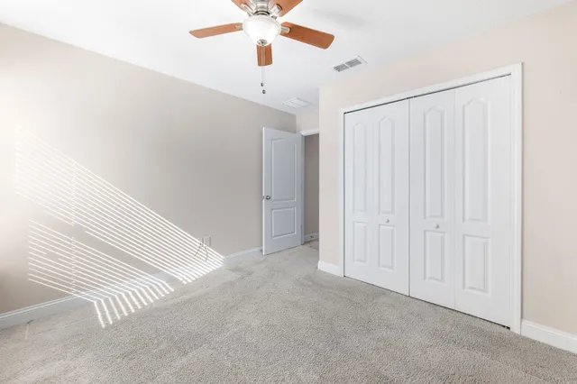 an empty room with a ceiling fan and a window