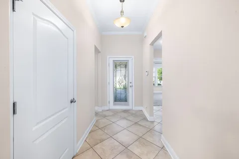 a view of a hallway with wooden floor and a chandelier