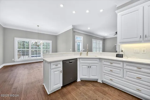 a spacious bathroom with stainless steel appliances granite countertop a sink and dishwasher with wooden floor