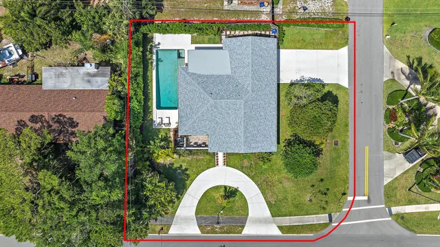 an aerial view of a house with swimming pool and garden