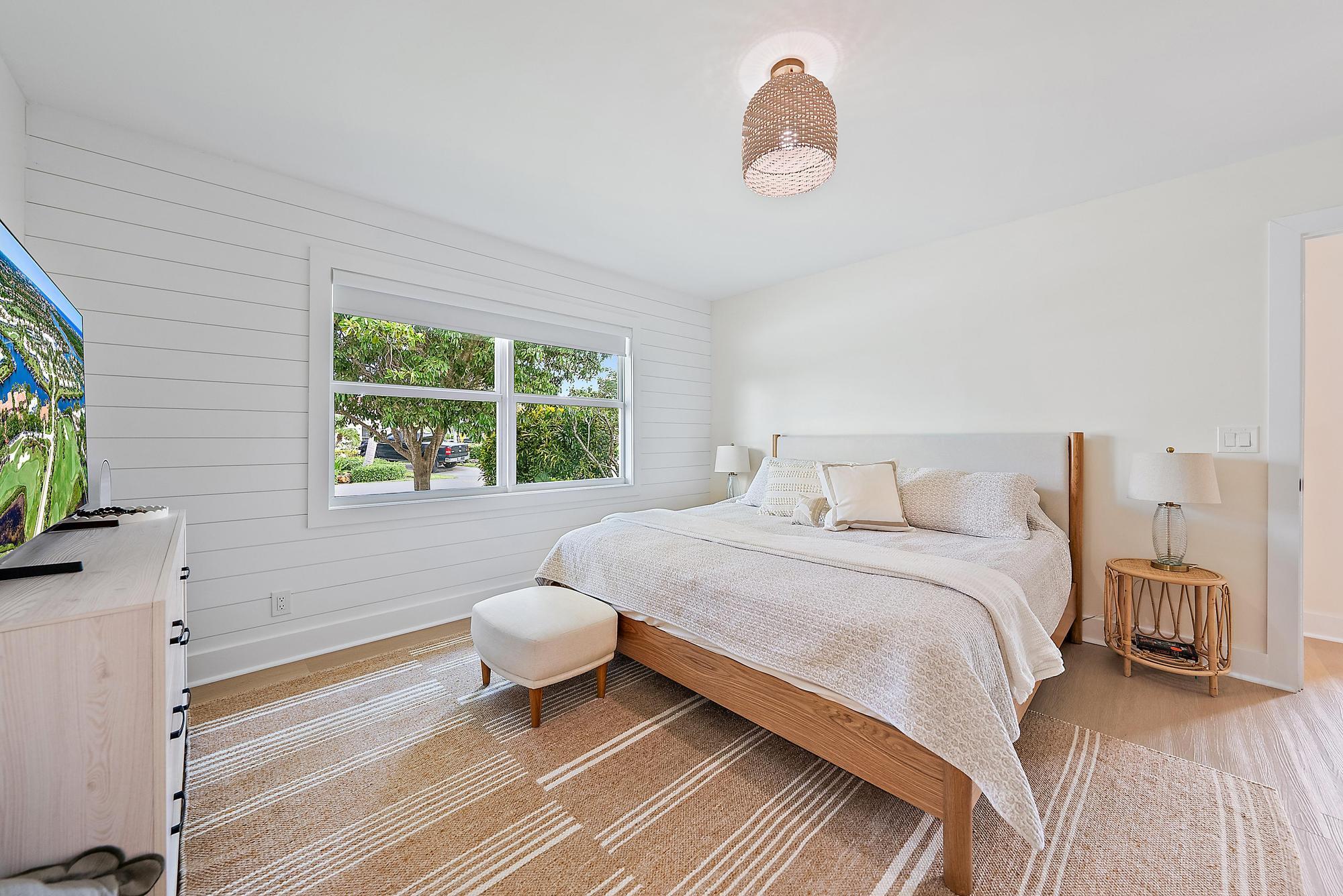 1604 Seabrook Road Tequesta, FL 33469 - Photo 16 of 42 a bedroom with a bed and a flat screen tv