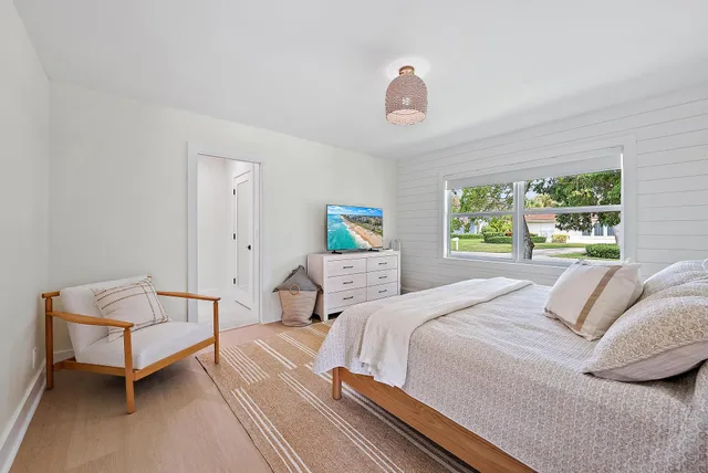 a bathroom with a granite countertop sink a toilet a mirror and shower