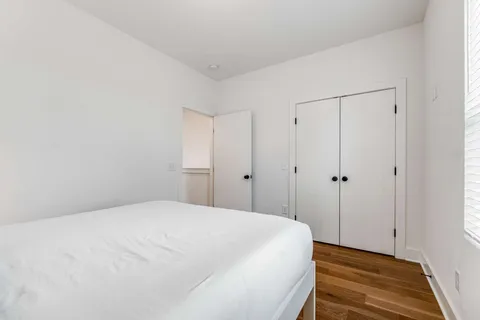 a bedroom with a bed and wooden floor