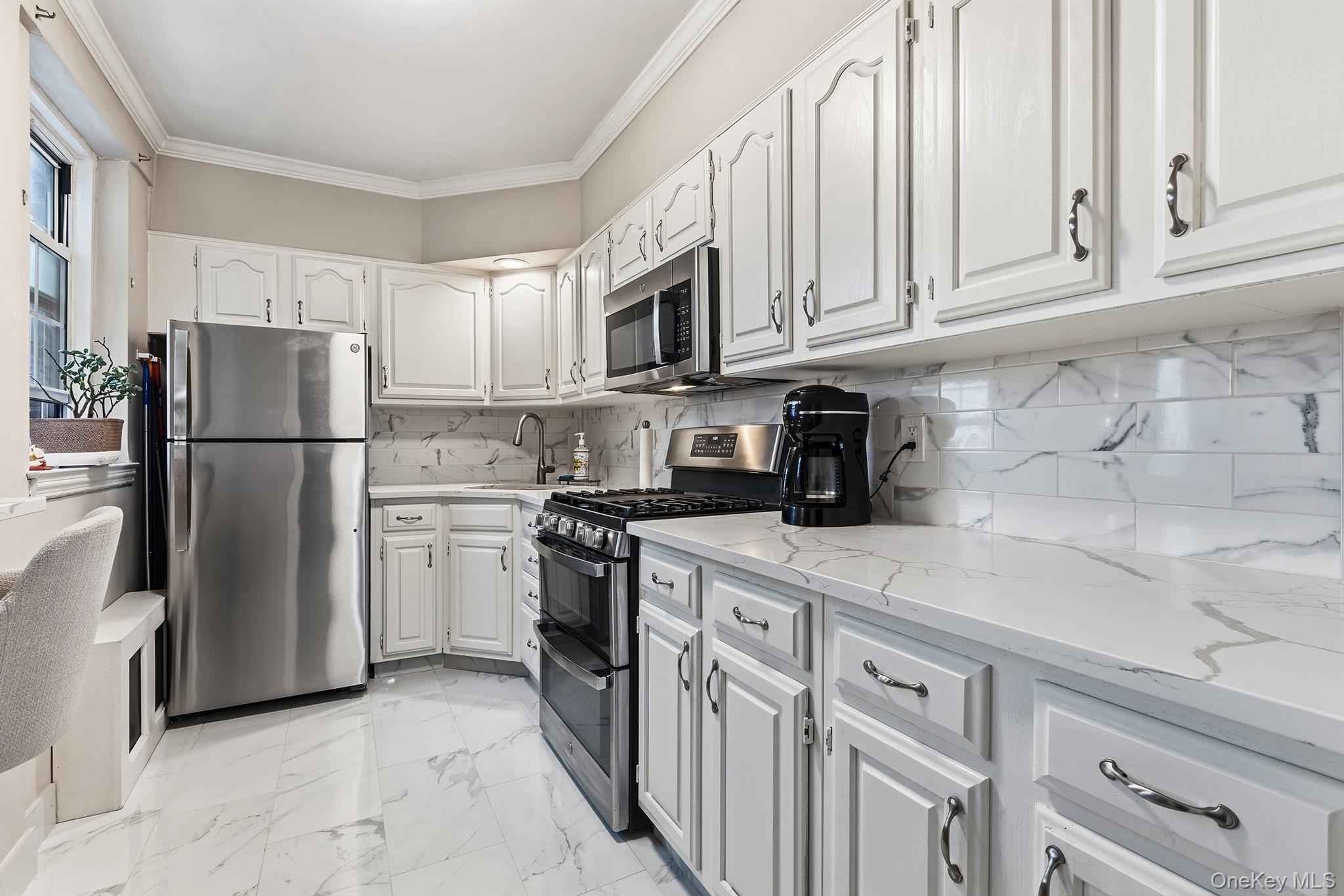 210 Pelham Road, Unit 6E New Rochelle, NY 10805 - Photo 5 of 15 a kitchen with stainless steel appliances granite countertop a refrigerator a stove a sink and white cabinets
