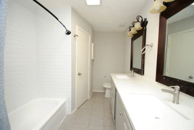 a bathroom with a tub sink and mirror