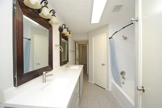 a bathroom with a tub sink and mirror