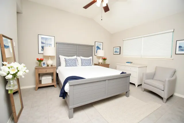 a bedroom with a bed mirror and a chandelier