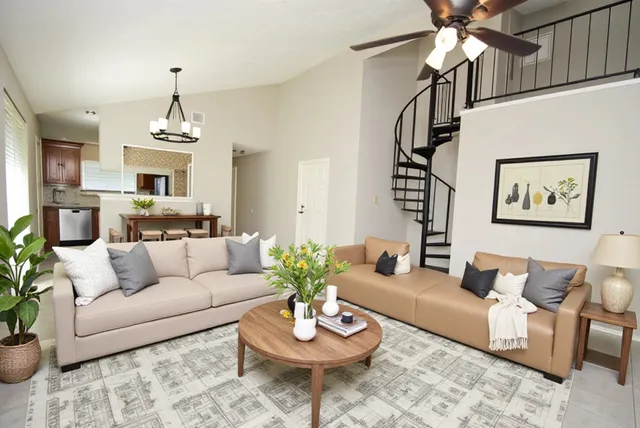 a living room with furniture a chandelier and a fireplace