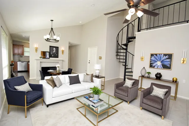 a living room with furniture a fireplace and a chandelier
