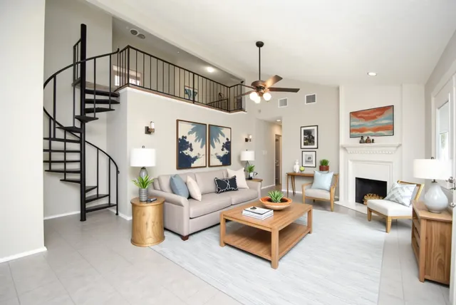 a living room with furniture a fireplace and a chandelier