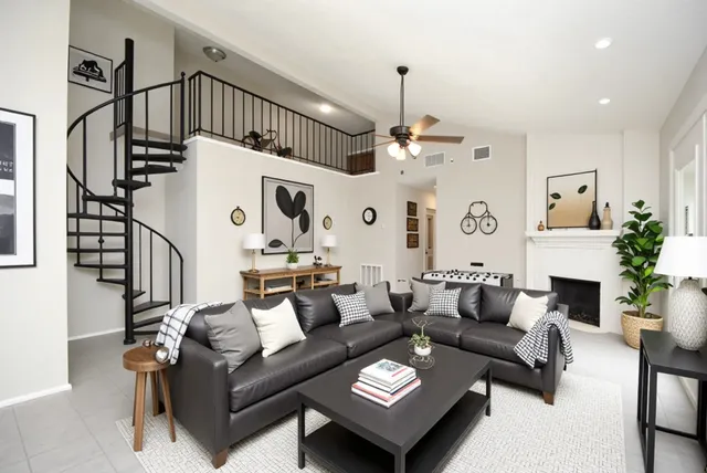 a living room with furniture a fireplace and a chandelier