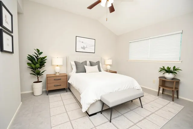 a bedroom with a large bed and a potted plant