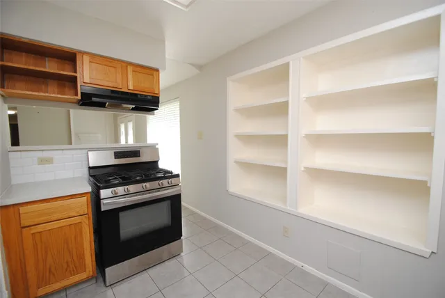 a kitchen with white cabinets and a stove top oven