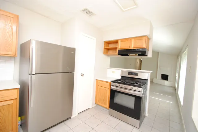 a kitchen with stainless steel appliances a refrigerator stove and microwave