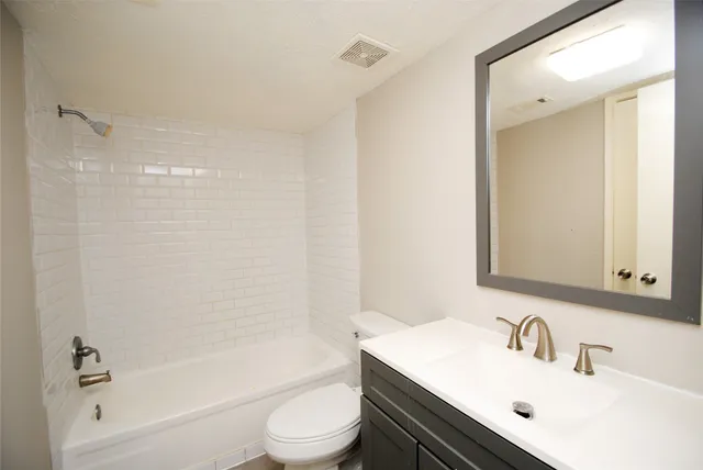 a bathroom with a sink mirror toilet and bathtub