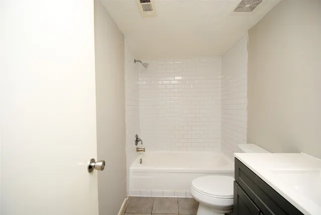 a bathroom with a bathtub shower sink vanity and toilet