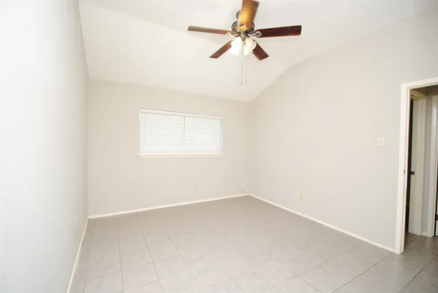 an empty room with a window and a fan