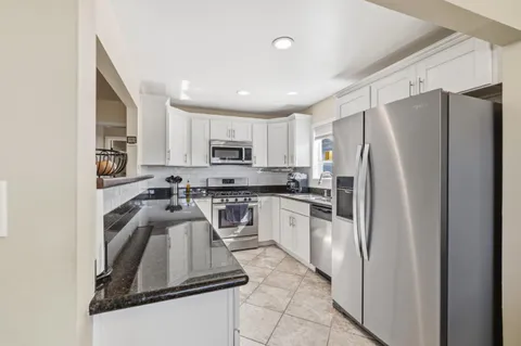 a kitchen with granite countertop a stove sink and cabinets