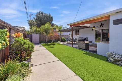 a view of a house with backyard and sitting area