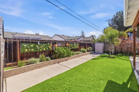 a backyard of a house with yard table and chairs